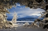 View west across a frozen Loch Morlich towards the setting sun. Taken in the Cairngorms National Park at Glenmore near Aviemore.
